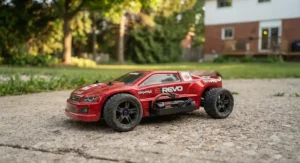 Close-up of a sleek red RC racing car with a USB-rechargeable battery cable visible.